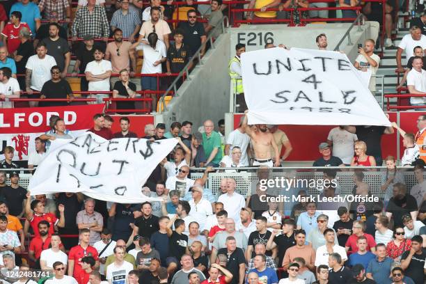 Manchester United fans hold up banners in protest against the club owners, The Glazers during the Premier League match between Brentford FC and...