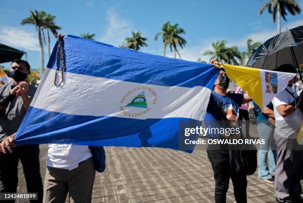 Woman holds a Nicaraguan national flag during a procession of the Virgin of Fatima within the grounds of the Metropolitan Cathedral in Managua on...