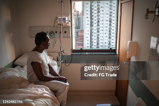 Senior patient looking through window at hospital Senior patient looking through window at hospital