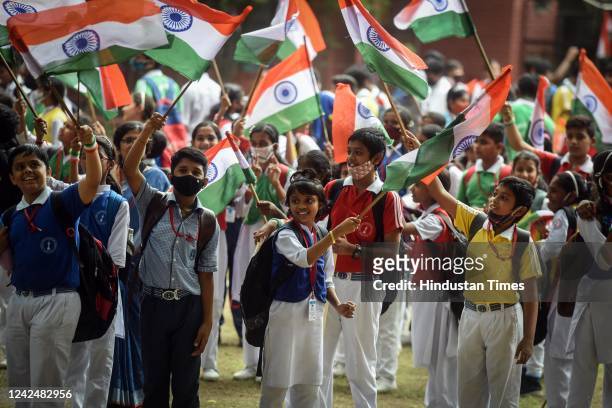 School students wave the Indian national flag ahead of the 75th Independence Day celebrations, at Kerla School, on August 13, 2022 in New Delhi,...