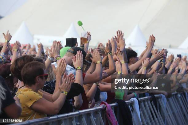 August 2022, Thuringia, Saalburg-Ebersdorf: Party guests celebrate and dance at the Bleilochtalsperre at the "SonneMondSterne" festival. It is one of...