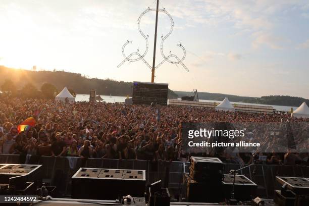 August 2022, Thuringia, Saalburg-Ebersdorf: Party guests celebrate and dance at the Bleilochtalsperre at the "SonneMondSterne" festival. It is one of...