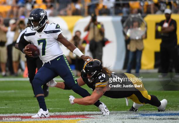 Geno Smith of the Seattle Seahawks is wrapped up for a sack by Henry Mondeaux of the Pittsburgh Steelers in the first quarter during a preseason game...