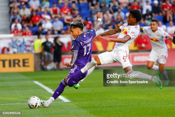 Orlando City forward Facundo Torres battles New York Red Bulls defender Kyle Duncan during the first half of the Major League Soccer game between the...