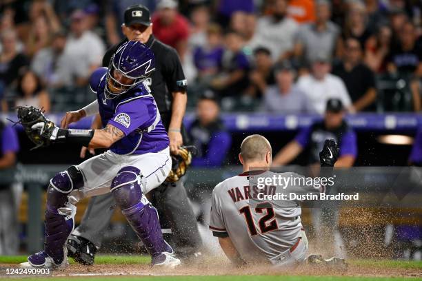 Daulton Varsho of the Arizona Diamondbacks slides safely accross home plate with an inside-the-park home run ahead of a tag attempt by Dom Nunez of...