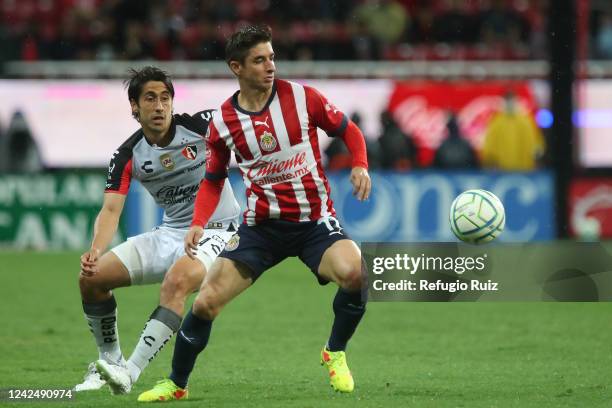 Isaac Brizuela of Chivas fights for the ball with Jose Abella of Atlas during the 8th round match between Chivas and Atlas as part of the Torneo...