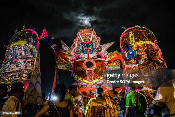 Malaysian Chinese people make a last preparation in front of a giant paper statue of the Chinese deity "Da Shi Ye" or "Guardian God of Ghosts" before...