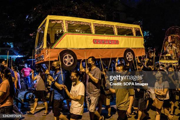 Malaysian Chinese people carry joss sticks and paper made bus during the Chinese Hungry Ghost Festival. According to Taoist and Buddhist beliefs, the...