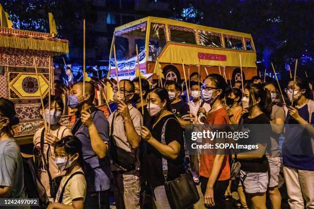 Malaysian Chinese people carry joss sticks in front of a paper bus during the Chinese Hungry Ghost Festival. According to Taoist and Buddhist...