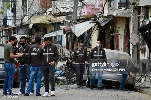 Members of the National Police inspect the site of an explosion, which the Ecuadorean government attributes to organized crime, in southern...