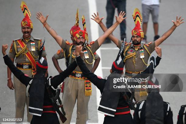 Pakistani Rangers and Indian Border Security Force soldiers take part in the Beating the Retreat ceremony during the Pakistans 75th Independence Day...