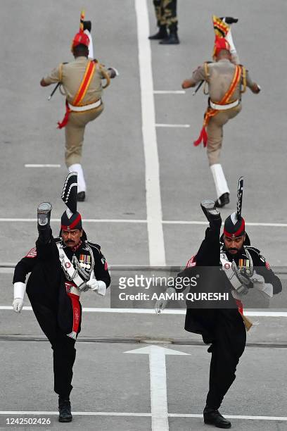 Pakistani Rangers and Indian Border Security Force soldiers take part in the Beating the Retreat ceremony during the Pakistans 75th Independence Day...