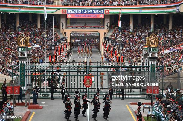 Pakistani Rangers and Indian Border Security Force soldiers take part in the Beating the Retreat ceremony during the Pakistans 75th Independence Day...