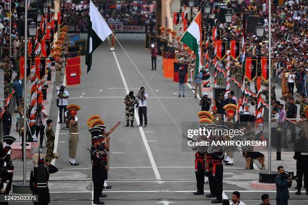 Pakistani Rangers and Indian Border Security Force soldiers take part in the Beating the Retreat ceremony during the Pakistans 75th Independence Day...