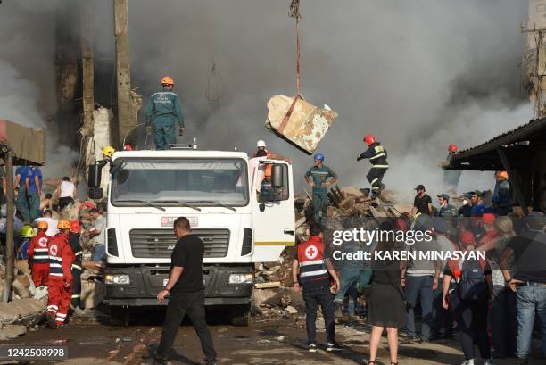 Rescue workers clear debris as they operate on the site of a retail market in the Armenian capital Yerevan on August 14 after an explosion sparked a...