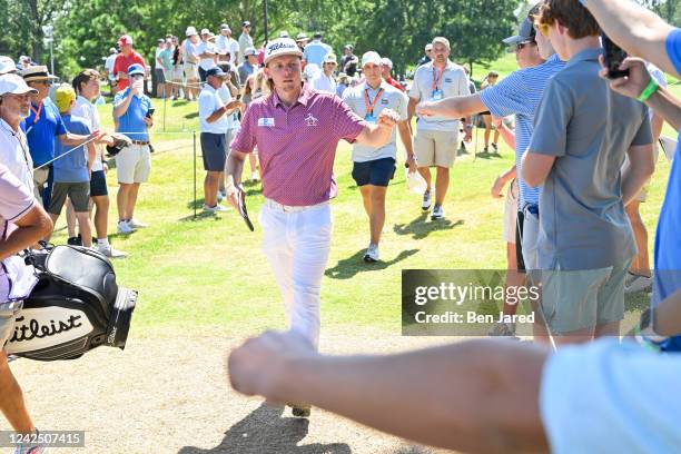 Cameron Smith of Australia gives knuckles to fans while walking off the ninth hole during the final round of the FedEx St. Jude Championship at TPC...