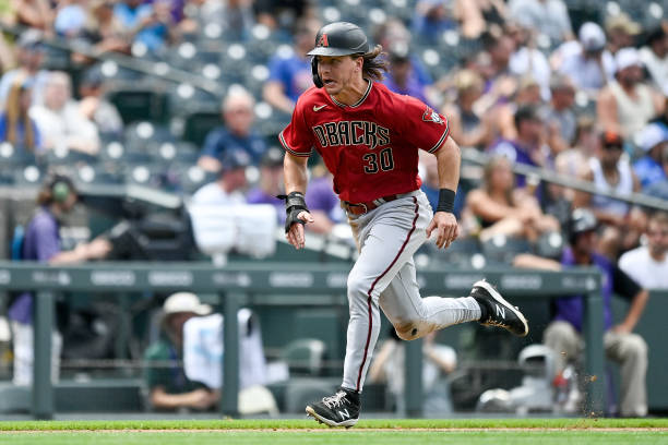 Jake McCarthy of the Arizona Diamondbacks runs to score on a fourth inning sacrifice fly ball against the Colorado Rockies at Coors Field on August...