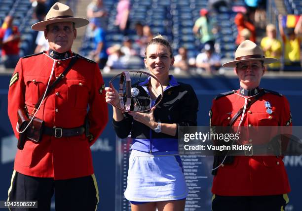 Simona Halep of Romania poses with Canadian Mounties as she celebrates her victory over Beatriz Haddad Maia of Brazil following the singles final of...