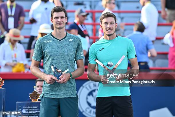 Hubert Hurkacz of Poland and Pablo Carreno Busta of Spain stand with their trophies after playing in three sets in the final round during Day 9 of...
