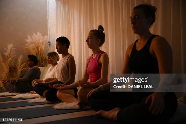 Yoga students attend a class at the studio "She's lost control" in East London, on July 14, 2022. Stacie Graham, a yoga teacher and corporate...