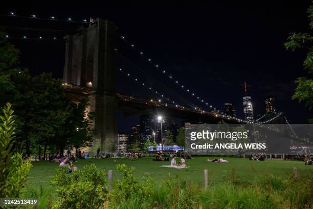 People sit in Brooklyn Bridge Park on August 14, 2022 in New York City.