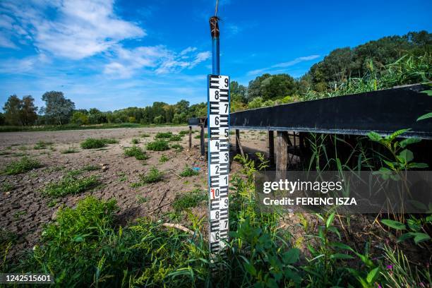 Photo taken on August 14, 2022 shows a levelling board at the dried-up bed of Lake Vekeri near Debrecen, eastern Hungary. - According to Hungarian...