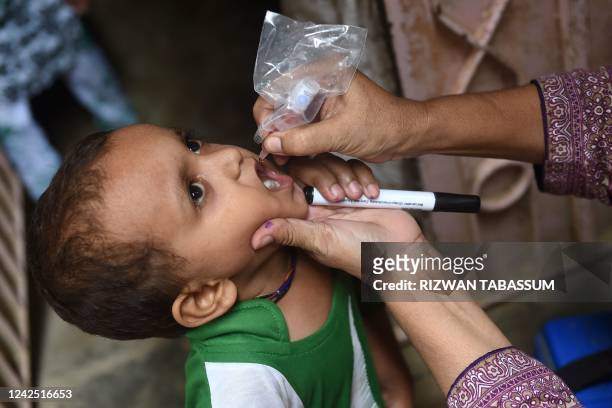 Health worker administers polio drops to a child during a polio vaccination campaign in Karachi on August 15, 2022.