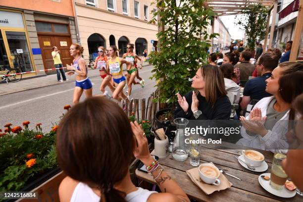 Athletes run past a café in the city center during the Women's Marathon Final on day 5 of the European Championships Munich 2022 on August 15, 2022...