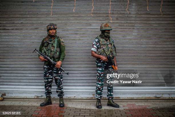 Indian paramilitary troopers stand guard in front the shuttered shops in the deserted city center, during India's Independence day celebrations on...