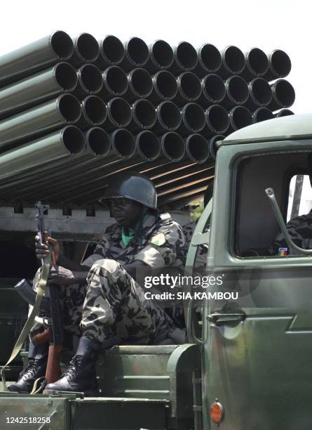 Soldier of the Malian army sits under the barrels of a rocket launcher during a military parade on September 22, 2010 in Bamako during celebrations...