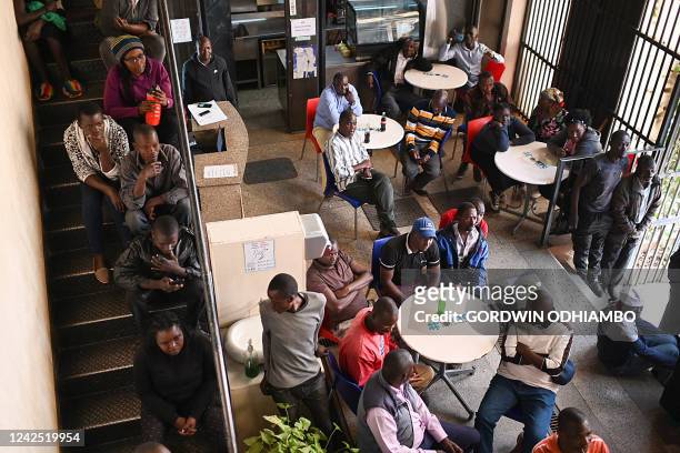 Residents watch television while waiting for Kenya's general election results in Kibera, Nairobi, on August 15, 2022. - Kenya was moving closer on...