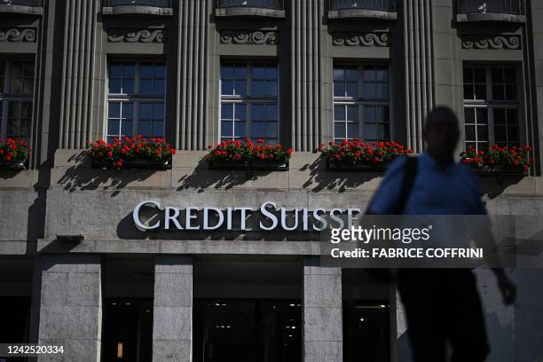 Man walks next to a branch of Swiss banking giant Credit Suisse in Bern on August 15, 2022. - Switzerland's scandal-hit banking giant Credit Suisse...