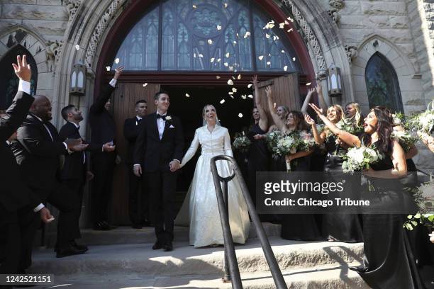 Los reciÃ©n casados Chris Lipari y Serena Stoneberg reciben una lluvia de pÃ©talos de flores afuera de la Iglesia Luterana Ebenezer en el vecindario...