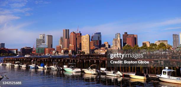 Boston, MA A view of boats lined up at a marina on the East Boston side with the City of Boston across the harbor in the early morning.