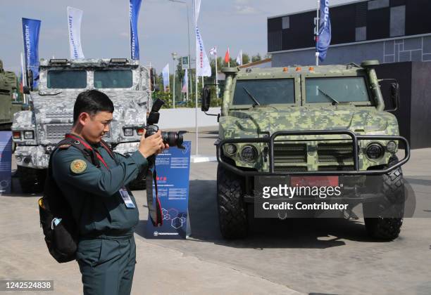 An officer from Kazakhstan takes a photo of the TIGR armored military vehicle during the International Military Technical Forum 'Army 2022', on...