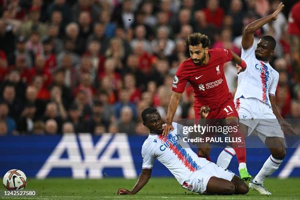 Liverpool's Egyptian striker Mohamed Salah fights for the ball with Crystal Palace's English defender Tyrick Mitchell and Crystal Palace's Malian...