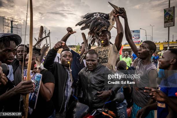 Men carry a Marabou stork protesting after the country's electoral commission chairman declared Deputy President William Ruto the winner over Raila...