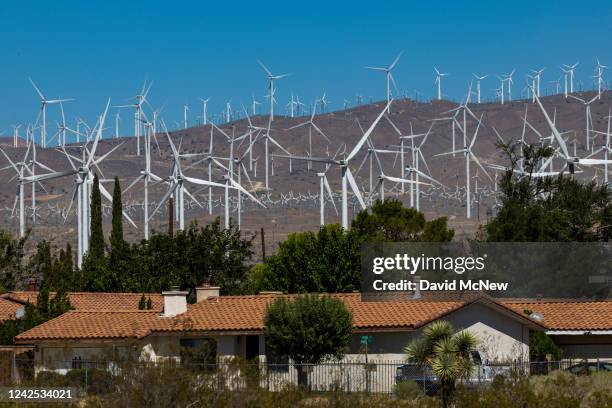 Wind turbines sprawl across the Mojave Desert next to a small community of homes on August 14, 2022 near Mojave, California. Out of concern for the...