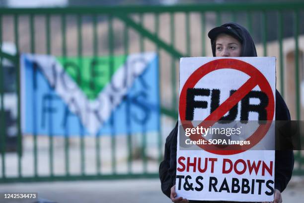 An animal rights activist holds an anti-fur farming placard during the demonstration. Animal rights activists are putting severe pressure on Phil...
