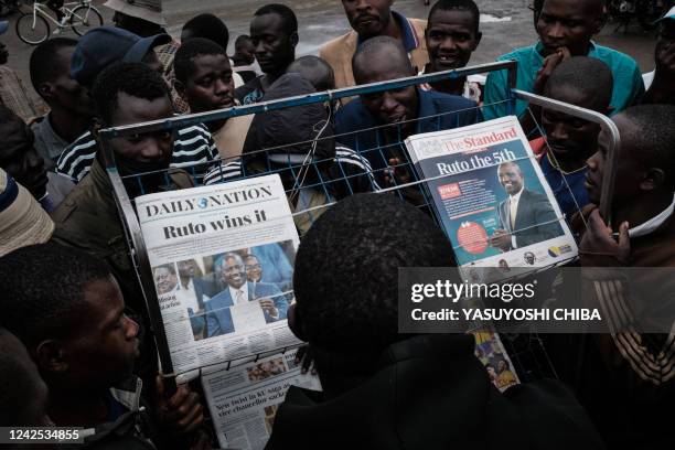 People argue at a newsstand, where The Standard and Daily Nation newspapers are sold, after Kenya revealed the new President Willium Ruto in Kisumu,...