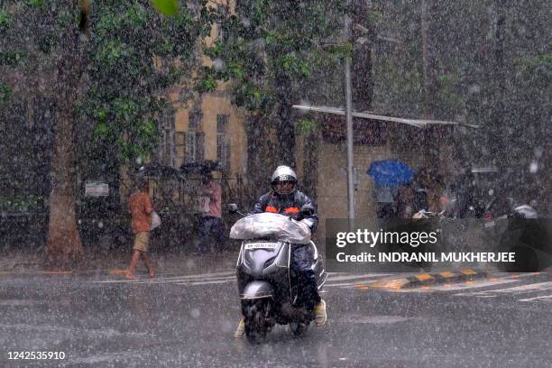 Motorist makes his way through a street during a heavy rain shower in Mumbai on August 16, 2022.