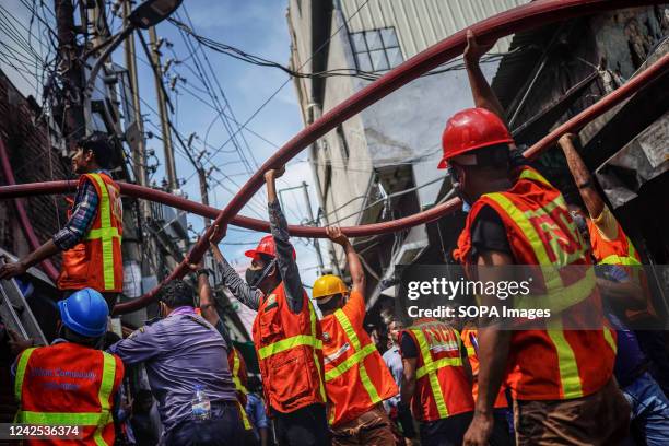 Volunteers help firefighters to extinguish a fire inside the building at a plastic factory. In Dhaka, six people are charred to death after a fire...