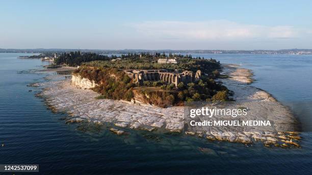 An aerial view taken on August 16, 2022 shows the peninsula of Sirmione on Lake Garda, northern Italy, as the lake's waters recede due to severe...