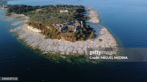 An aerial view taken on August 16, 2022 shows the peninsula of Sirmione on Lake Garda, northern Italy, as the lake's waters recede due to severe...