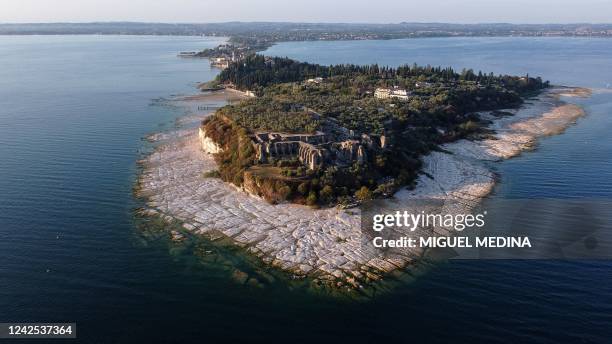 An aerial view taken on August 16, 2022 shows the peninsula of Sirmione on Lake Garda, northern Italy, as the lake's waters recede due to severe...