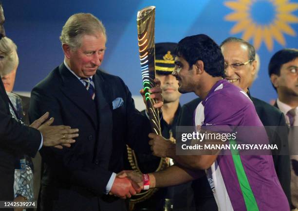 Britain's Prince Charles, Prince of Wales receives the Queen's Baton from Indian wrestler Sushil Kumar at the XIX Commonwealth Games opening ceremony...