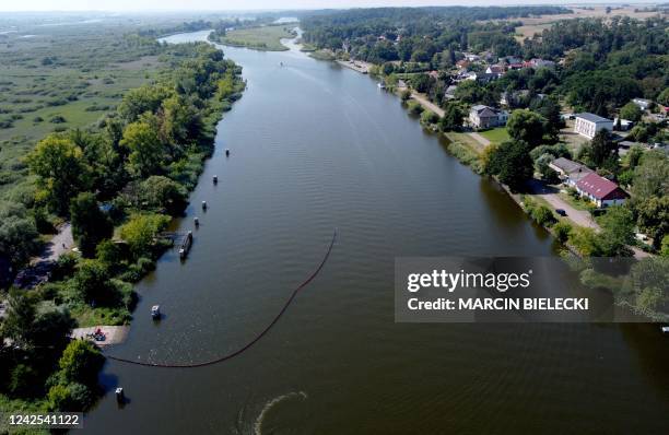 An aereal view shows Polish firefighters setting up a floating damm to catch dead fish from the river Oder, on August 16 in Gryfino near Szczecin,...