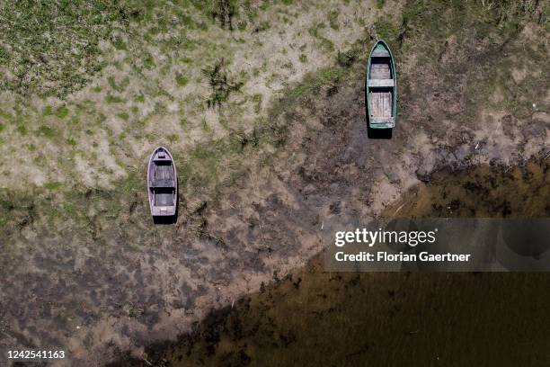 Boats are pictured on a nearly dried out strand on August 16, 2022 in Waldhufen, Germany. Many waters in Germany are already or nearly dried out...