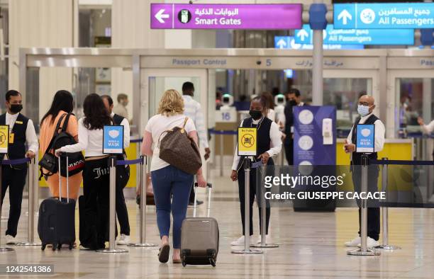 Picture shows passengers walking towards the gates at terminal 3 at Dubai international Airport, in the Gulf emirate of Dubai, on August 16, 2022.