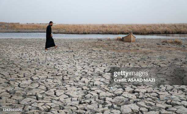 Demonstrator approaches a boat stuck in the dried-up bank of a canal, during a rally at the Umm El Wadaa marsh, south-east of the Iraqi city of...